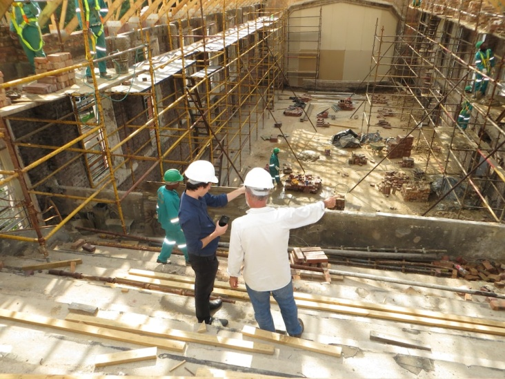 Two men wearing safety helmets talking at a construction site