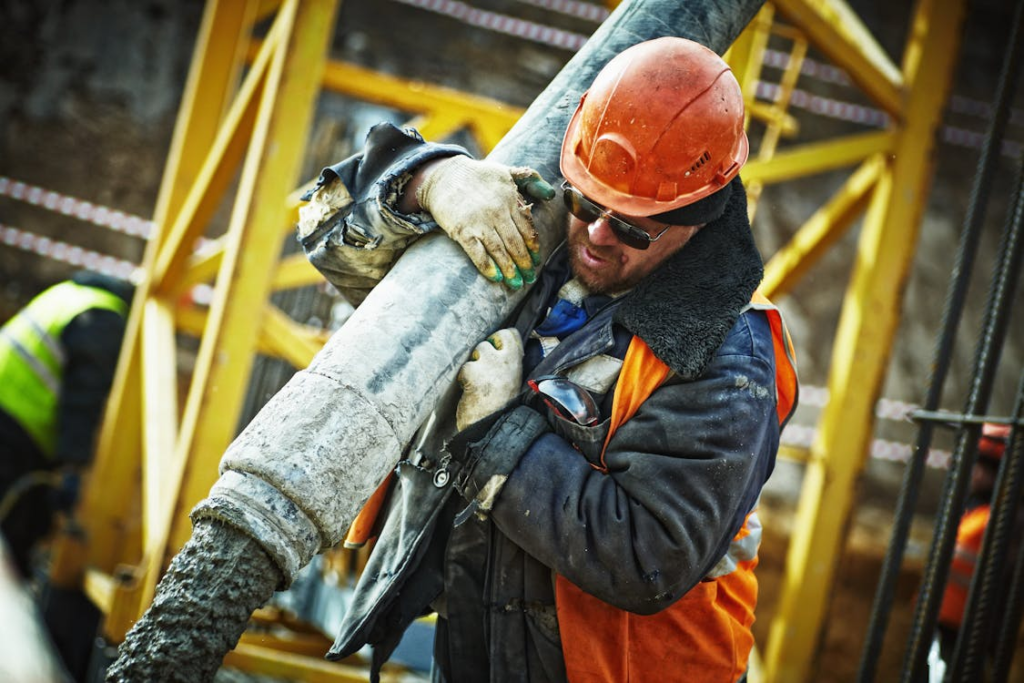 A construction worker carrying a pipe