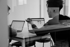 Black and white image of people working on their laptops