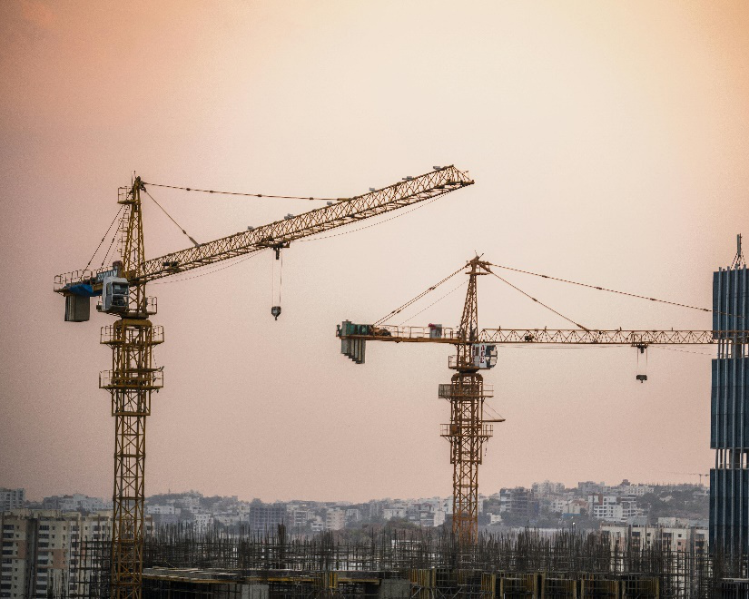 An image of cranes at a construction site  