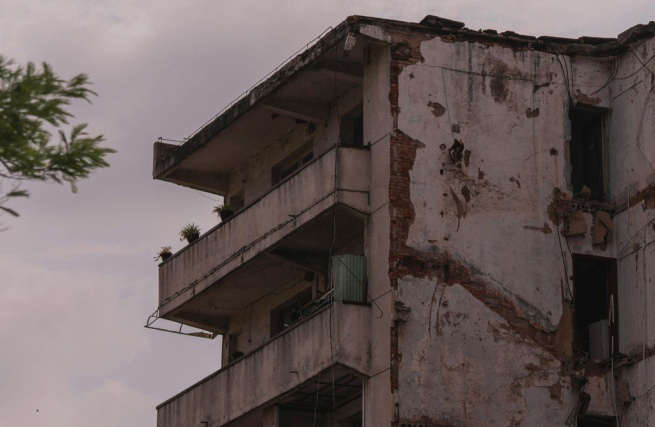 A close-up of a concrete structure with visible cracks and damage.