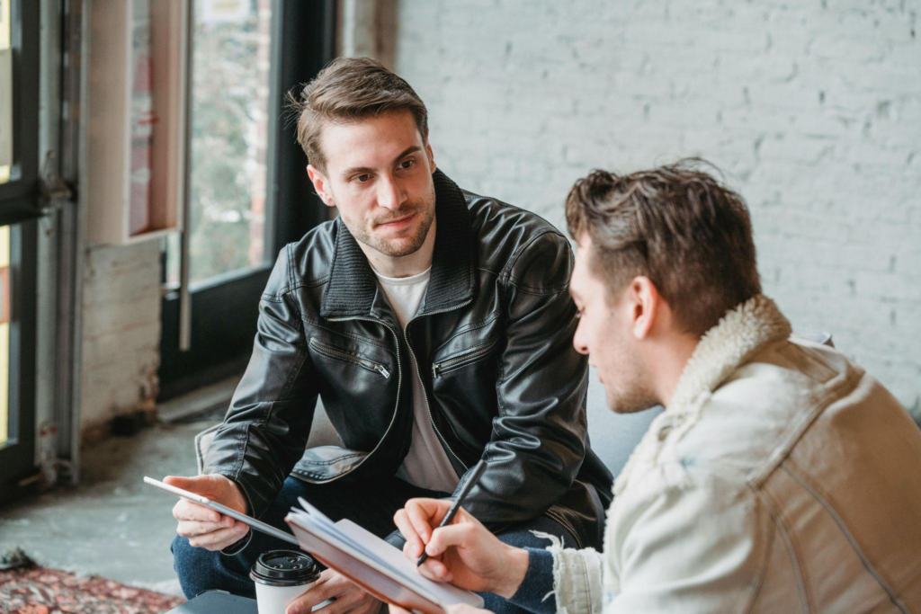 Professionals reviewing construction schedules on a tablet to prevent disputes.