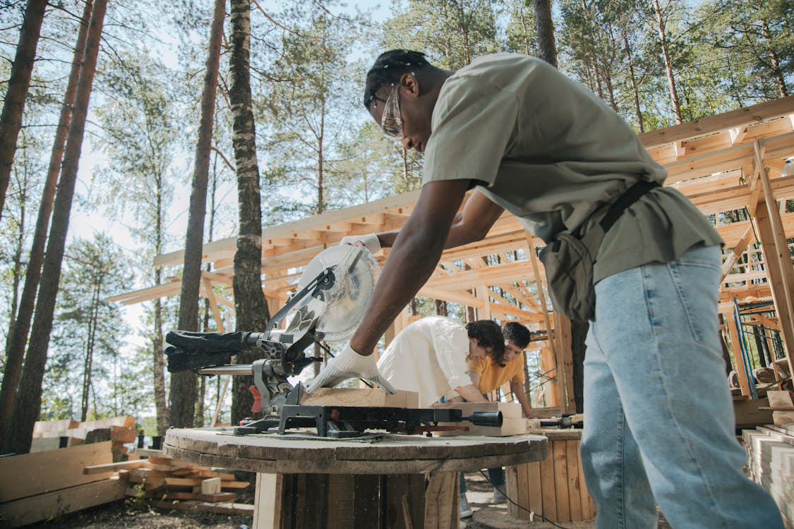 An image of a person using a saw on a wood plank 