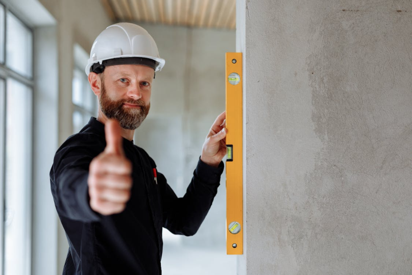 An image of a man wearing a white helmet and showing a thumbs-up