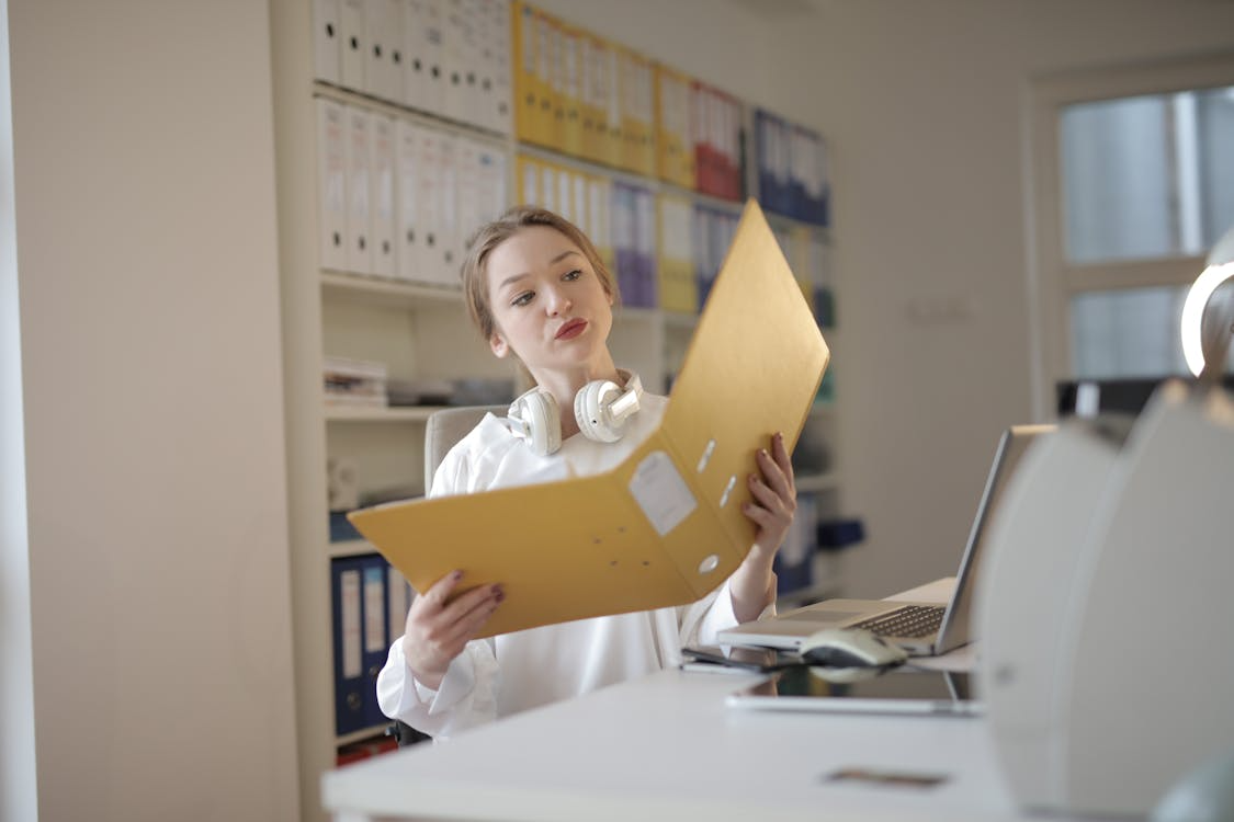 An image of a woman looking at some documents in a folder 