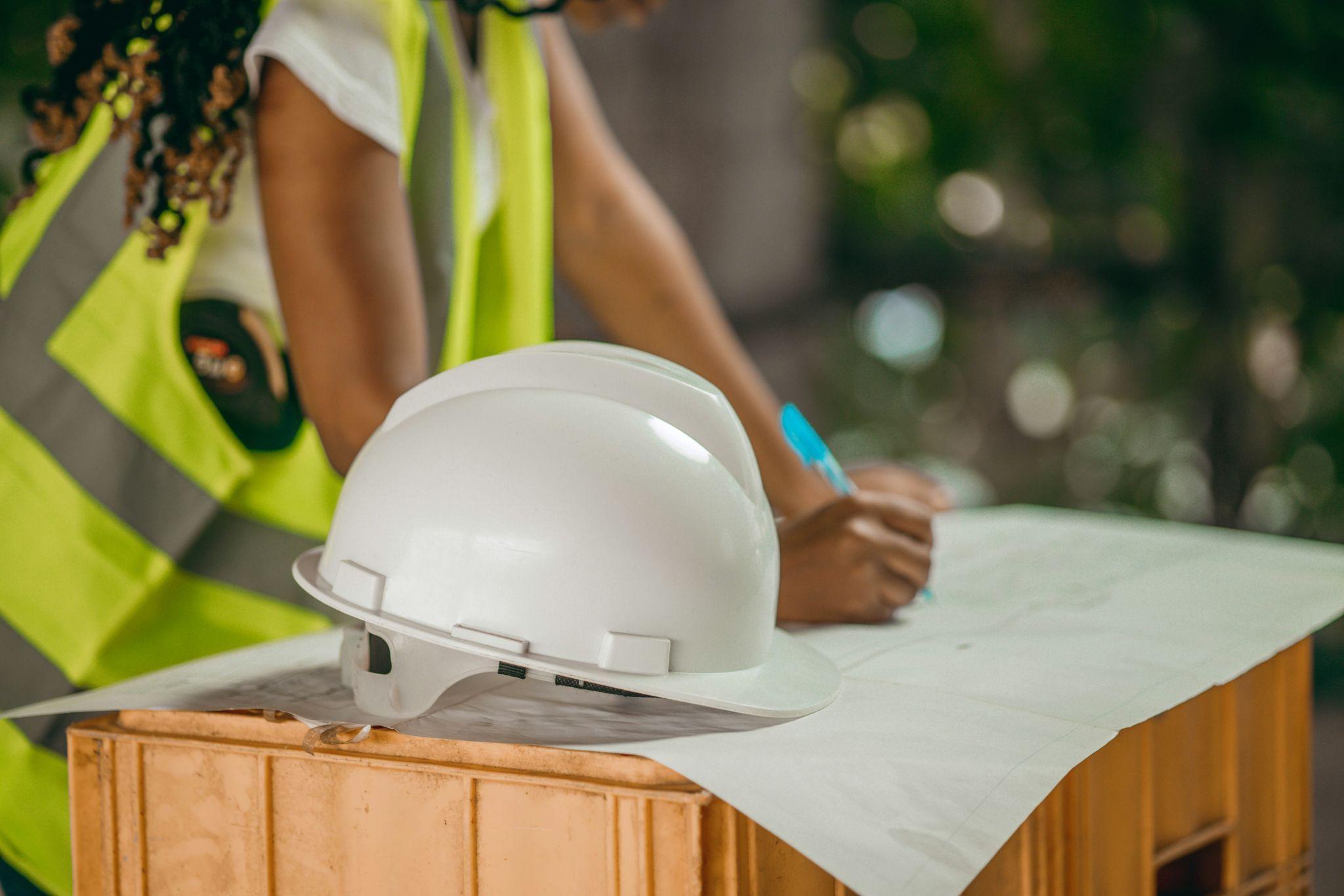a construction worker working on a table with a white helmet on it