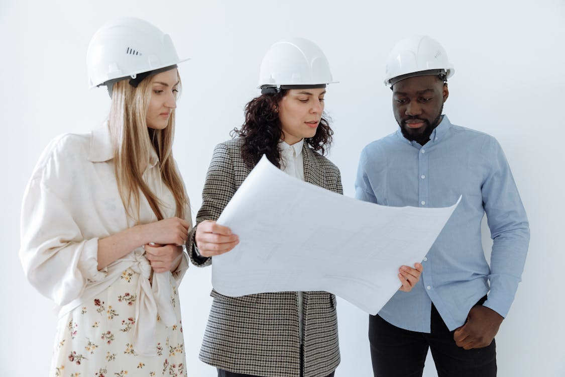 Construction professionals reviewing project schedules and cost reports at a job site
