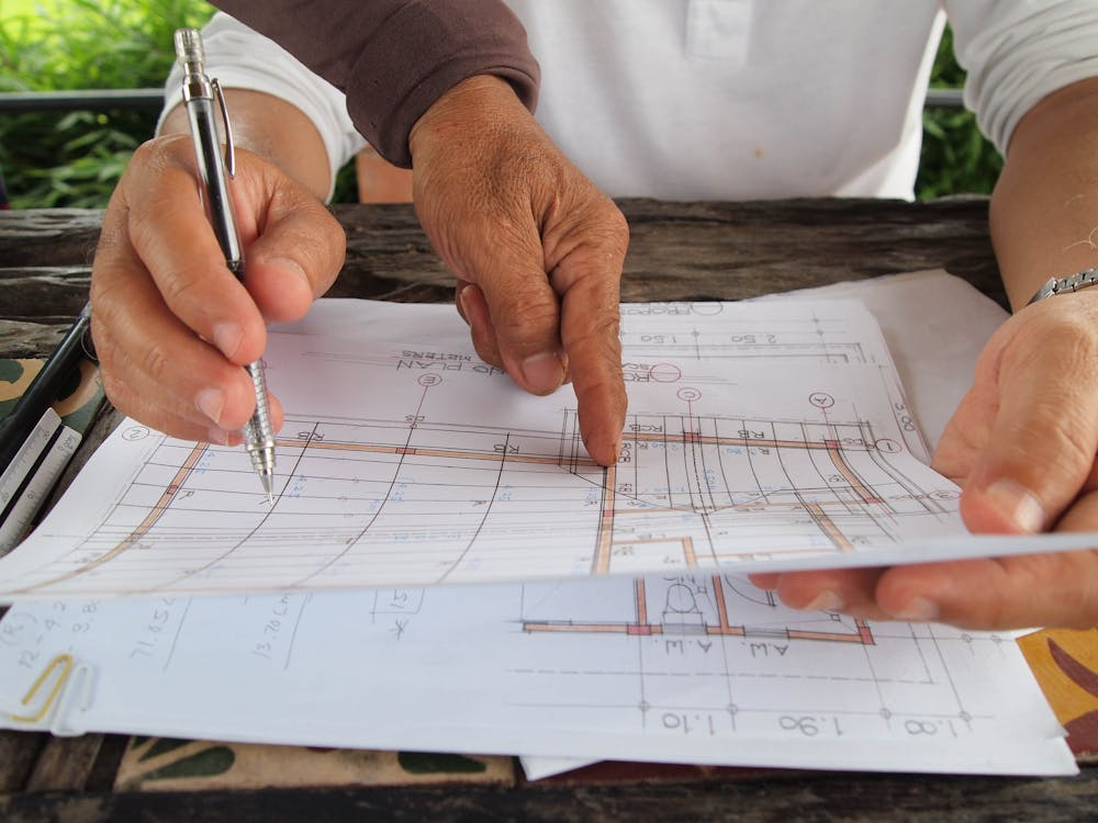 An image of people working on construction blueprints