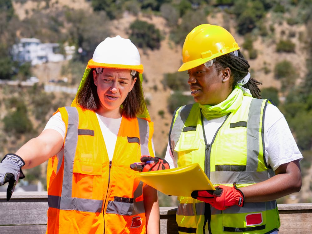 An image of construction workers wearing helmets and jackets  
